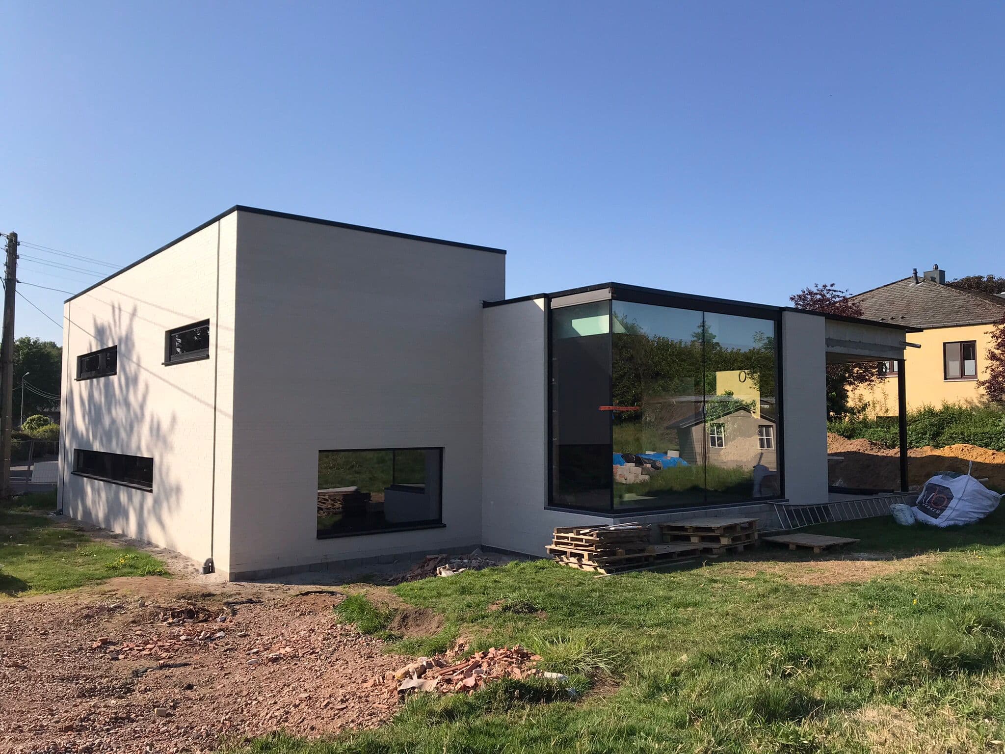 Hedendaagse witte kubieke woning met grote glazen gevel — Bouwwerken Apers